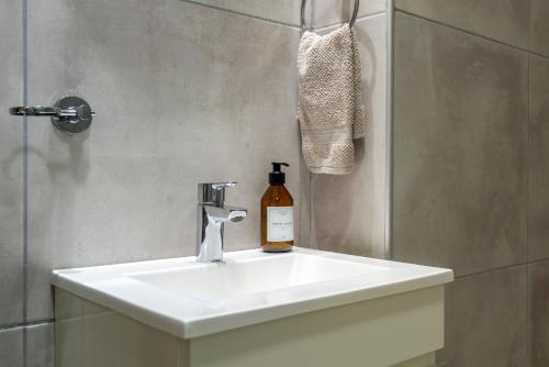 a bathroom sink with a bottle of wine on it at Departamento céntrico II con estacionamiento gratis in San Salvador de Jujuy