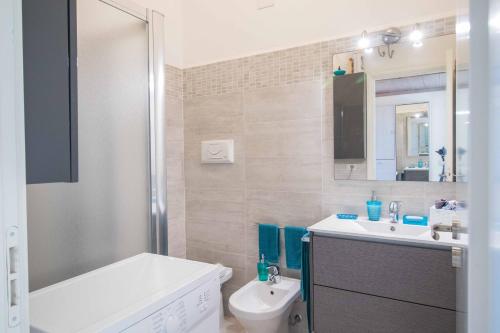 a bathroom with a sink and a toilet and a mirror at Casa Pace Stintino in Stintino