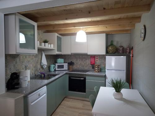 a kitchen with white appliances and a table in it at Amieira do Tejo guest house in Barca da Amieira