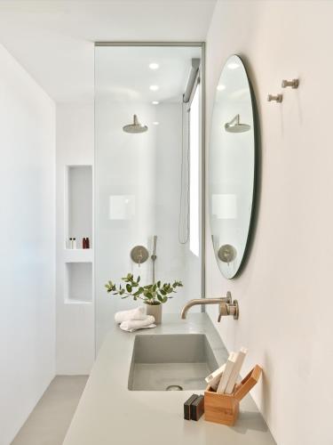 a white bathroom with a sink and a mirror at Olithos Villas in Krotiri
