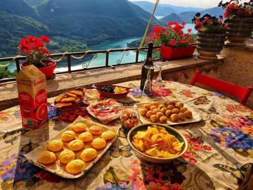 einen Tisch mit Lebensmittelplatten und Aussicht in der Unterkunft La Casa Sul Fiordo Lago del Turano in Paganico