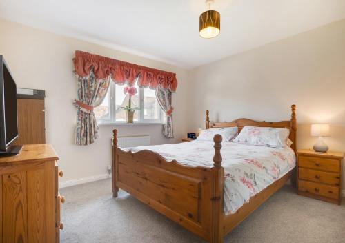 a bedroom with a wooden bed and a television at Bishops Hill in Acomb