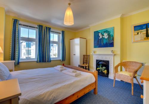 a bedroom with a large bed and a fireplace at Chy An Porth in Padstow