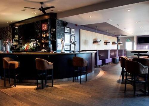 un bar en un restaurante con mesas y sillas en Flat in Hamilton, South Lanarkshire, en Hamilton