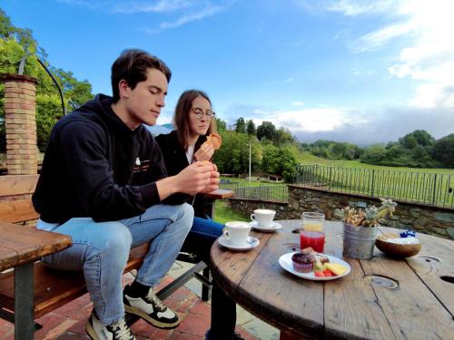 a man and a woman sitting at a table eating food at Casa Vacanze Le Fornaci in Laterina