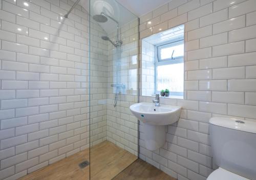 a white bathroom with a sink and a toilet at 1 Redsteads 