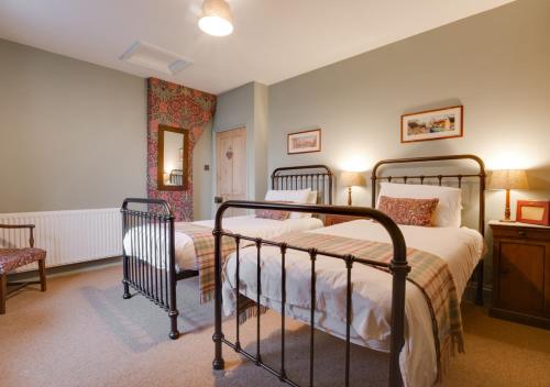 1 dormitorio con 2 camas, mesa y silla en Pantile Cottage, en Pickering
