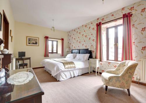 una camera con letto, tavolo e sedia di Oxnop Cottage a Gunnerside