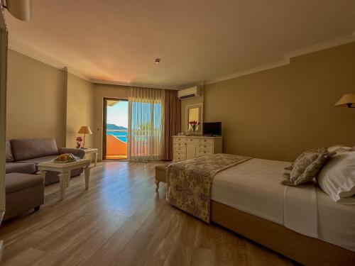 a bedroom with a bed and a living room with a couch at Hawaii Hotel in Marmaris