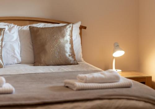 1 dormitorio con 1 cama con 2 toallas en Cuthbert Cottage, en Warenford