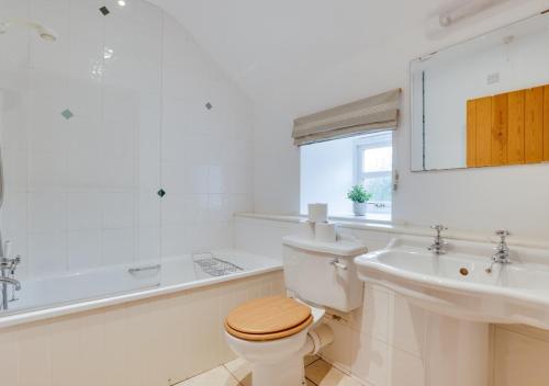 ein Badezimmer mit einem WC, einem Waschbecken und einer Badewanne in der Unterkunft Hethpool Mill in Kirknewton