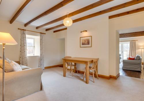 ein Wohnzimmer mit einem Tisch und einem Sofa in der Unterkunft Hethpool Mill in Kirknewton