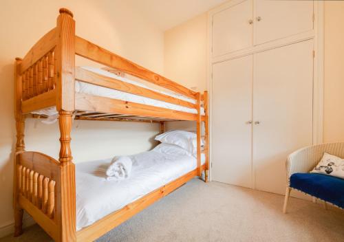 a bedroom with two bunk beds and a chair at The Barns in Ellingham