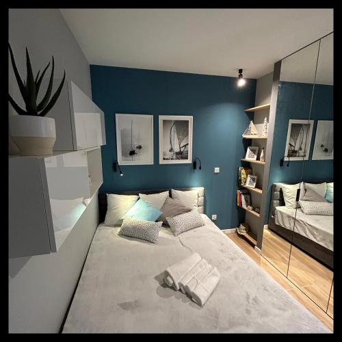 um quarto com paredes azuis e uma cama com almofadas em Apartament Walizka em Gdansk