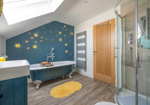 baño con bañera y estrellas en la pared en Under The Stars en Chatton