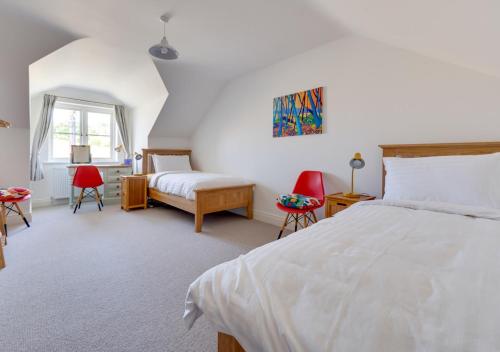 1 dormitorio con 1 cama blanca grande y sillas rojas en Under The Stars en Chatton