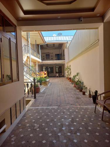 um corredor vazio de um edifício com plantas e bancos em Yusuf Gold House em Samarkand