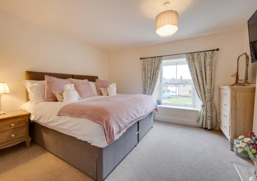 Un dormitorio con una cama grande y una ventana en Munton Cottage, en Crakehall