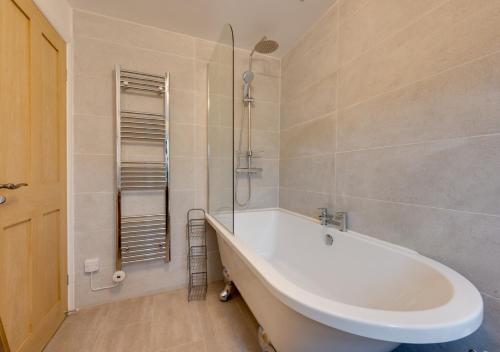 a bathroom with a white tub and a shower at Munton Cottage in Crakehall