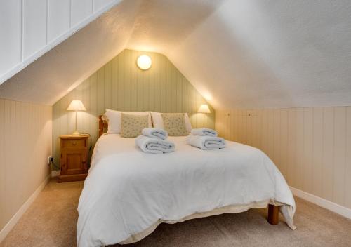 a bedroom with a large white bed with towels on it at Coldburn Cottage in Kirknewton