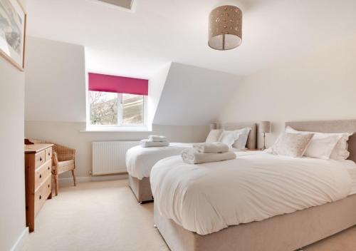 1 dormitorio blanco con 2 camas y ventana en Dunsdale House, en Kirknewton