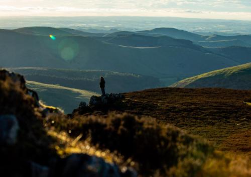 a person standing on the top of a mountain at Coldburn Cottage in Kirknewton