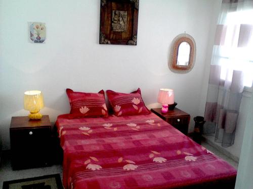 a bedroom with a pink bed and two lamps at Excellent Appartment Sousse in Sousse