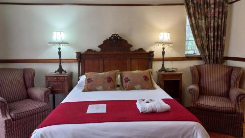 a hotel room with a bed with two chairs at Brooklyn Place in Pretoria