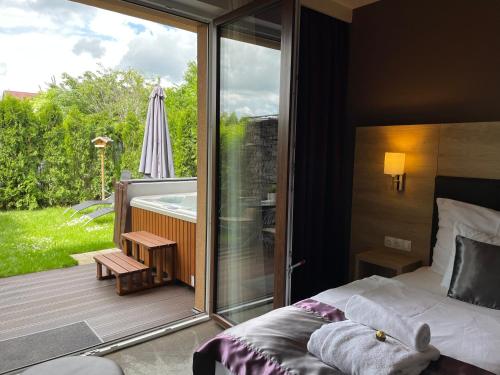 a bedroom with a bed and a balcony with an umbrella at Villa Aruba & Private SPA Suites in Keszthely