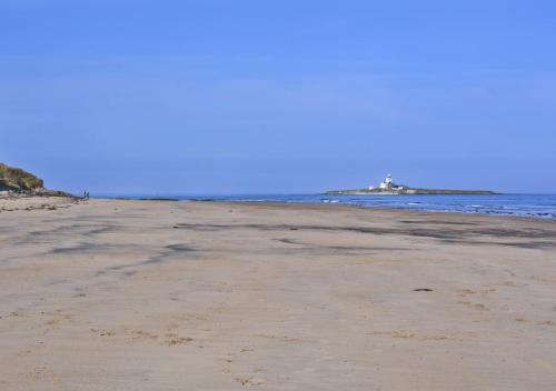an empty beach with the ocean in the background at Beach View Cottage in Amble