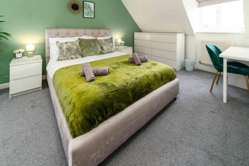 a bedroom with a large bed with a green blanket at Ideal Lodgings In Openshaw in Manchester