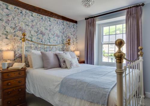 a bedroom with a white bed and a window at Memories Cottage in Milnthorpe
