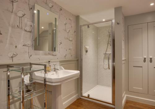 a white bathroom with a sink and a shower at Memories Cottage in Milnthorpe