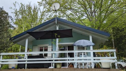 a small house with a blue roof and an umbrella at Il était une fois in Champeau