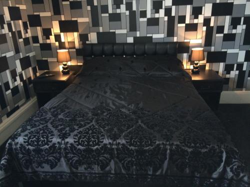 a bedroom with a large bed with two night stands at The Carlton Hotel in Folkestone