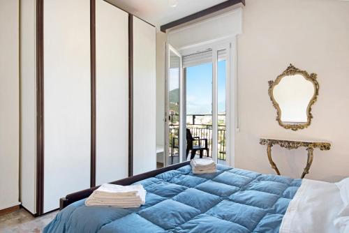 Un dormitorio con una cama azul y un balcón. en Condominio Sereno, en Rapallo