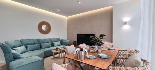a living room with a blue couch and a table at Salt n Blue Villa Palase in Palasë