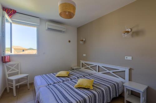 1 dormitorio con 1 cama con 2 almohadas amarillas en Maison Fab Jo - Proche de lîle rousse, en Belgodère