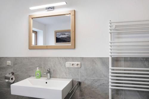 bagno con lavandino bianco e specchio di Alpspitz a Garmisch-Partenkirchen