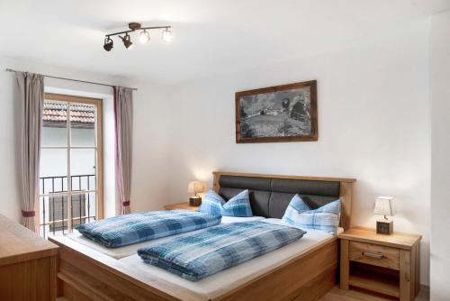 una camera con 2 letti con cuscini blu e una finestra di Alpspitz a Garmisch-Partenkirchen