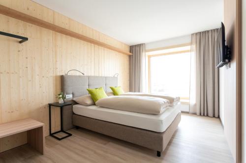 a bedroom with a large white bed with yellow pillows at eee Hotel Eberstalzell 