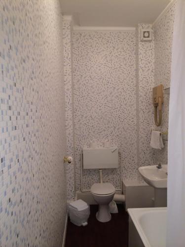 a bathroom with a toilet and a sink at The Carlton Hotel in Folkestone