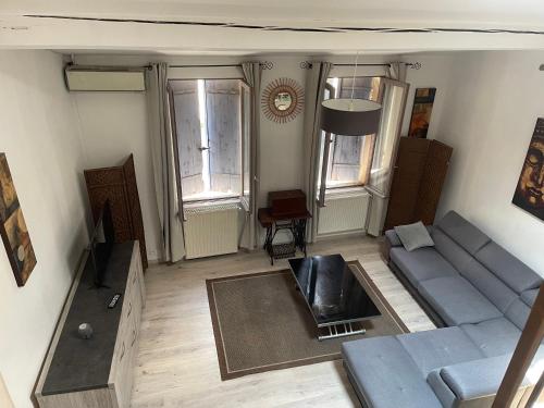 - un salon avec un canapé bleu et quelques fenêtres dans l'établissement Appartement, à Carcassonne