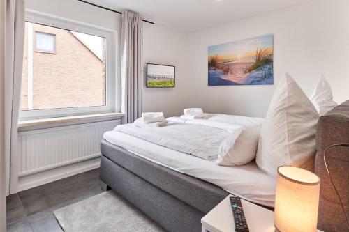 a bedroom with a large bed and a window at Haus Deepensoll 39 Ankerplatz in Pelzerhaken