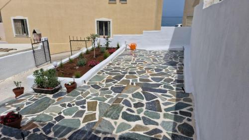 une passerelle en pierre avec des plantes en pot sur un bâtiment dans l'établissement Mythical Luxury Apartment, à Naxos Chora