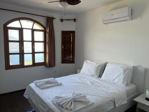 1 dormitorio con 1 cama con sábanas blancas y ventana en Private House with Pool and Sea View in Antalya, en Yeşilköy