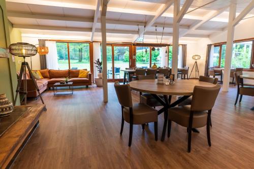 een woonkamer met een tafel en stoelen bij Hotel de Stoppelberg in Beekbergen