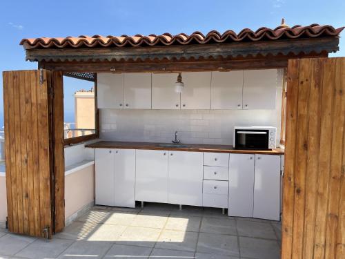 cocina con armarios blancos y encimera con microondas en Private House with Pool and Sea View in Antalya, en Yeşilköy
