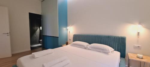 a bedroom with a white bed with two pillows at Salt n Blue Villa Palase in Palasë