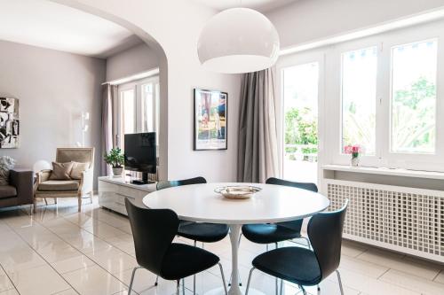 sala de estar con mesa blanca y sillas en Agave Apartment by Quokka 360 - flat with large terrace in Lugano, en Viganello